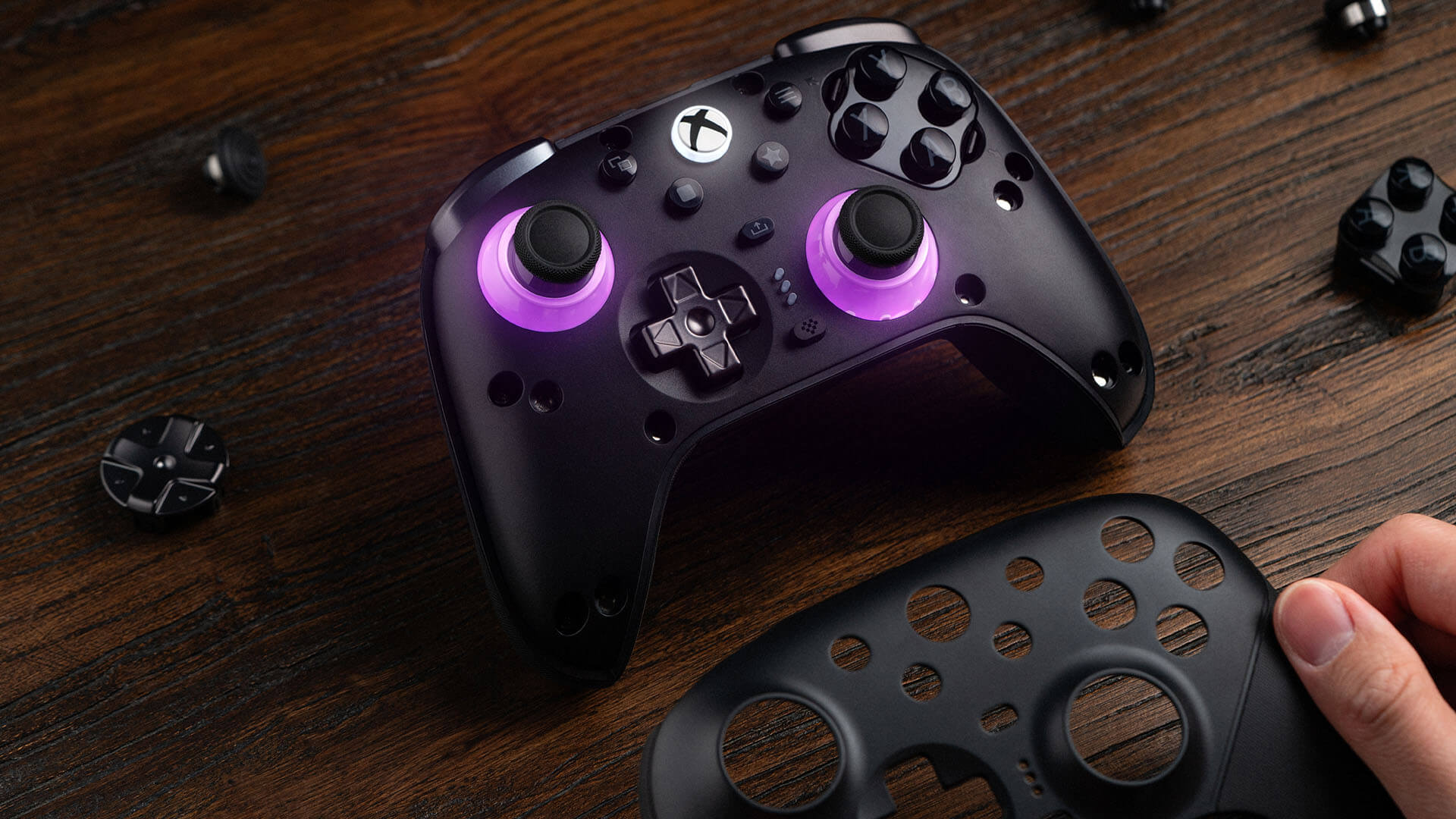 Official 8BitDo promotional photograph showing the Ultimate 3E faceplate being removed and its modular controls